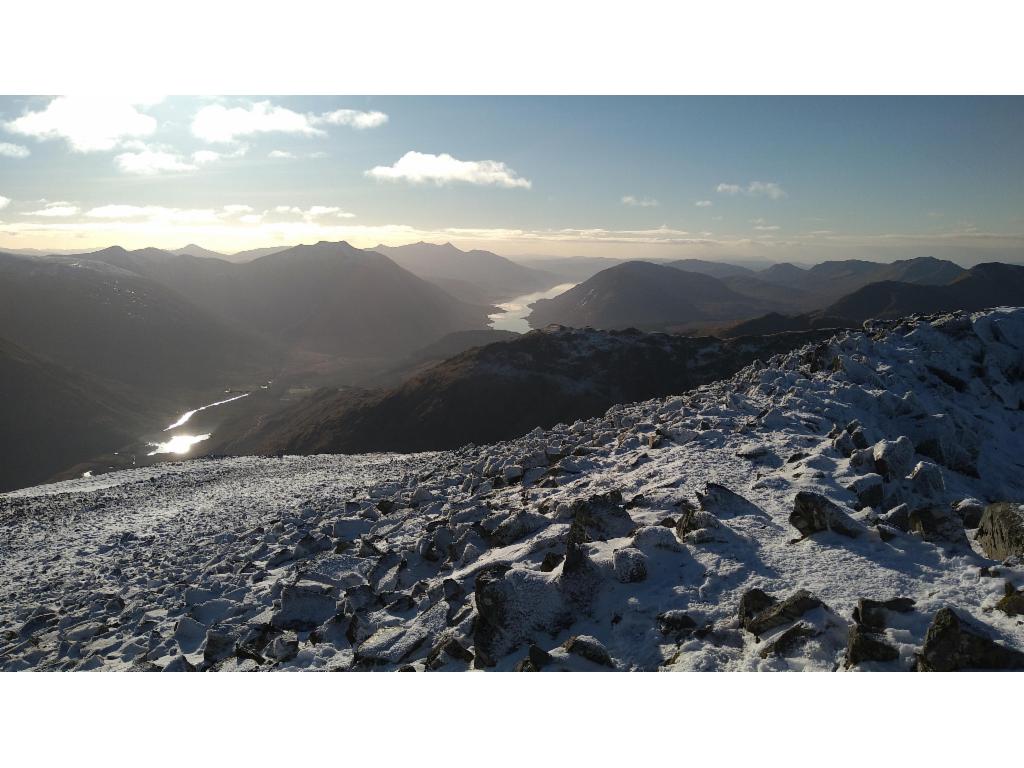 Sun rays hitting Lochan Urr, with Loch Etive in the distance seen from Bealach Dearg